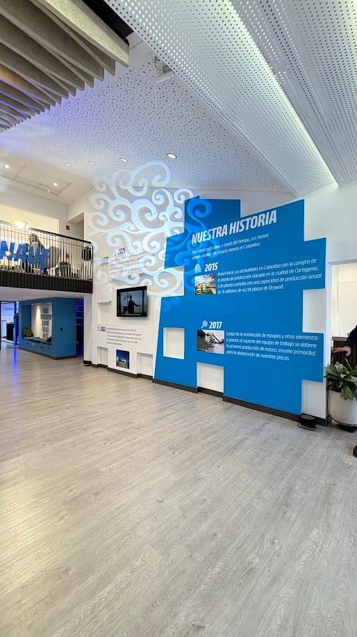 Vestíbulo con cielorraso de listones ondulados y muro de relieves