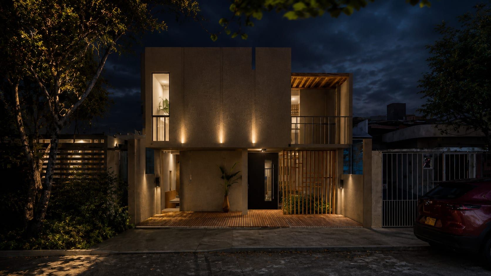 Fachada de noche con iluminación cálida en el acceso